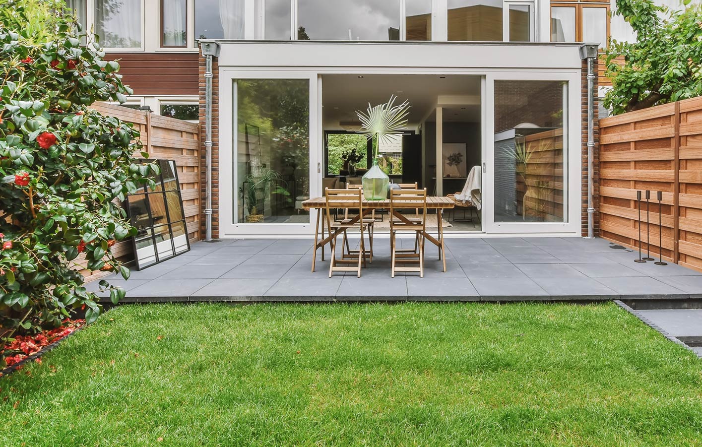 Terrasse mit Steinfliesen und Gartenmöbeln